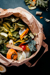 Kitchen food waste in recyclable paper bag for compost. Sustainable lifestyle, plastic free. Vegetable and fruit peels, scraps from meal preparation