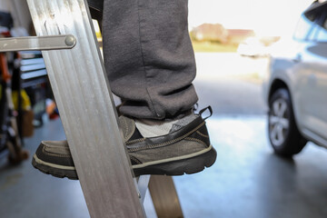 A man climbing a ladder in a garage © Robin