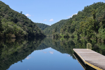 looking down a glass-like lake from the boat launch to the mountains
