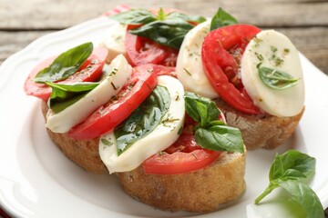 Delicious sandwiches with mozzarella cheese, tomatoes and basil on table, closeup