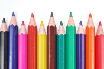 A close-up, top-down view of a vibrant array of colorful wooden pencils, fanned out to display their diverse hues, ideal for art, education, or creativity themes.