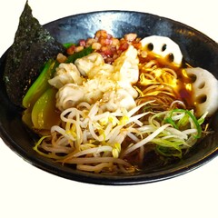 Chinese ramen in broth with rice noodles, bacon, tortellini, seaweed, soy, and vegetables in a bowl on a white background. Close-up, isolated.
