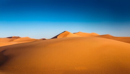 golden sand dunes under clear blue sky stretching across horizon in minimalist composition