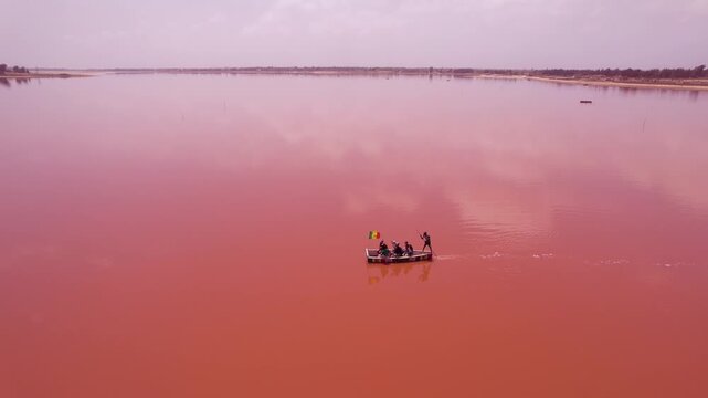 SENEGAL - 7.14.2025 - Fantastic aerial view of a man rowing a boat across Dakar, Senegal's Pink Lake.