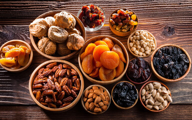 variety of dried fruits and nuts displayed on a wooden tablet