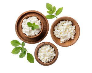 Overhead view of three wooden bowls filled with cottage cheese, garnished with fresh mint leaves