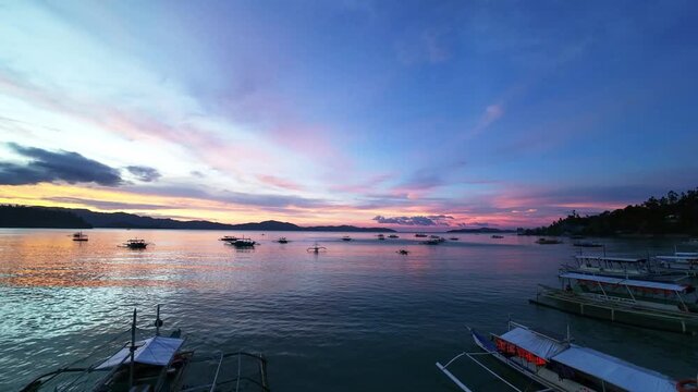 Evening scene with anchored boats at sunset in Port Barton, Palawan, Philippines Boats anchored during sunset in Port Barton, Palawan, Philippines