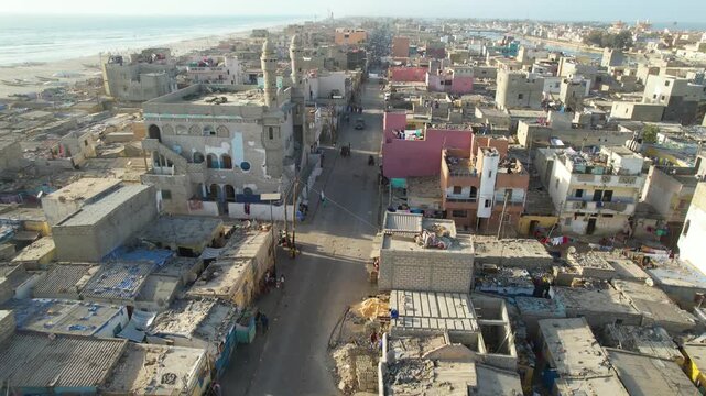 SENEGAL - 7.16.2025 - Incredible aerial footage moving up a busy road in a beachside neighborhood on Senegal's Island of Saint-Louis.