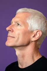 Obraz premium Visual idea of style for aging men. Purple solid background. A strong and graceful male displaying confidence. Chic men's shoulder-length taper haircut - midlife white man with white hair.