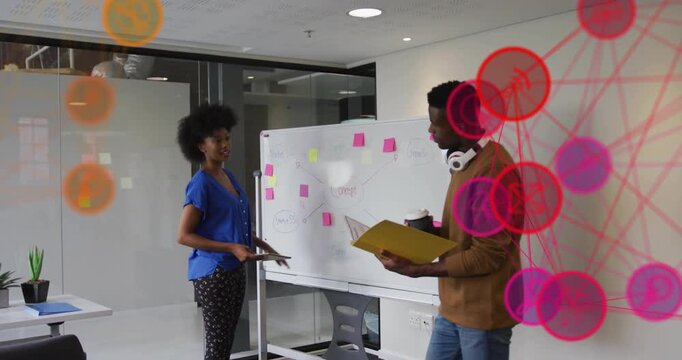 Woman peeling pink sticky note causing node overlay with peer arranging mind-map in business office