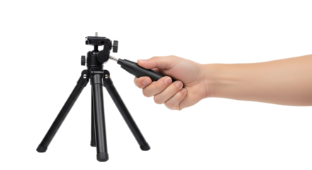 Hand holding a remote control to adjust a small camera tripod