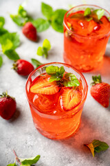 Fresh summer cocktail with strawberry and ice. Strawberry soda drink on the rustic background.