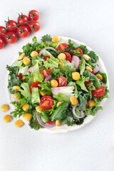 Summer green salad with tomatoes, redish and lupin beans on white background. Top view. Vegan food