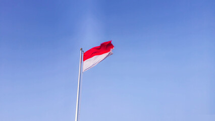 The Indonesian national flag fluttered loudly against the backdrop of a bright blue sky in the morning.