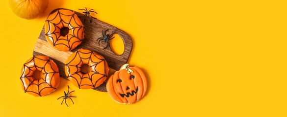 Tasty donuts for Halloween, cookie and spiders on yellow background with space for text