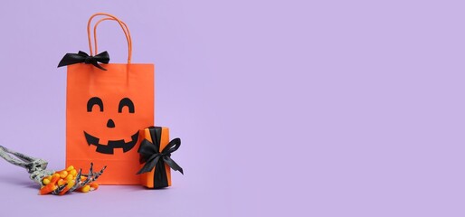 Skeleton hand with treats, Halloween gift box and shopping bag on lilac background with space for text