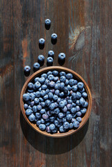 Blueberries in wooden bowl on a wooden