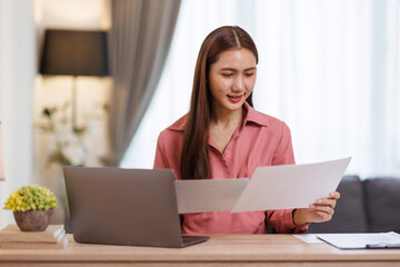Fototapeta premium Asian woman using laptop sitting working from home. 
