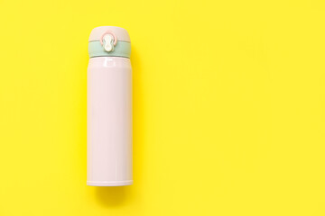 Modern pink thermos on yellow background