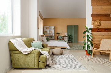 Interior of modern bedroom with houseplants, green decor elements and wooden wall