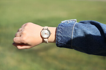 Female hand with wristwatch outdoors, closeup