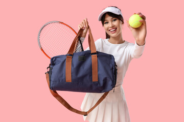 Female tennis player with sports bag and ball on pink background