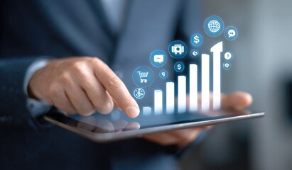 Businessperson uses tablet to interact with growing bar graph and connected icons
