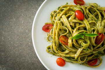 fettuccine spaghetti pasta with pesto sauce and tomatoes