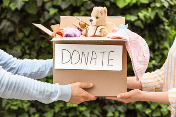 Young woman and man with box for donation outdoors, closeup