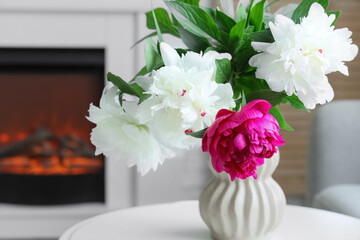 Vase with beautiful peonies on coffee table in living room, closeup