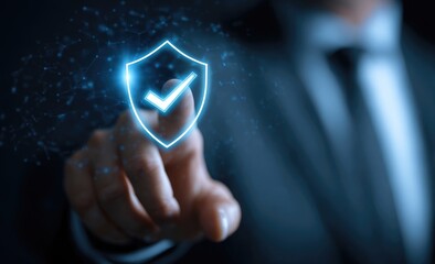 Business person's finger touches a glowing blue shield icon with a checkmark, symbolizing digital security
