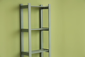Empty bookshelf near green wall