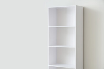 Empty bookshelf near light wall