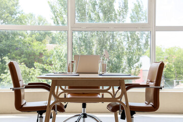 Table with laptops and clipboards prepared for business meeting in conference hall