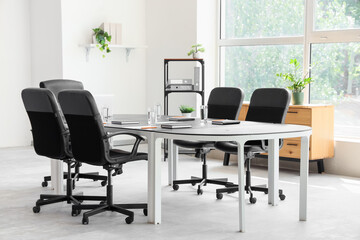 Interior of conference hall with table, shelf unit and plants