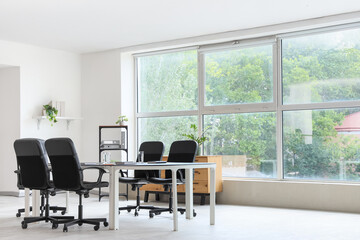 Interior of conference hall with table, shelf unit and plants