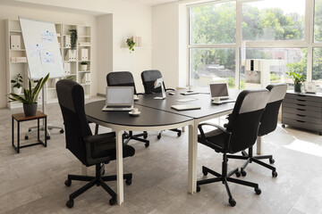 Interior of conference hall with table, flipchart and plants