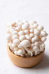 Fresh white Shimeji mushroom in wooden bowl on white background, Asian edible mushroom, Food ingredients
