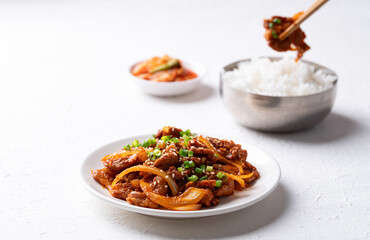 Korean stir fried spicy pork (Bulgogi) with cooked rice and kimchi on white background