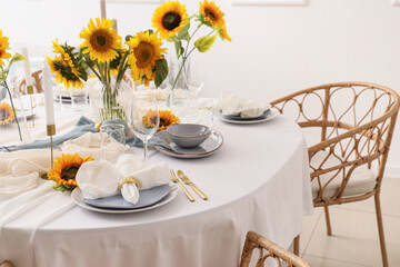 Elegant table serving with plates, folded napkin and beautiful sunflowers, closeup