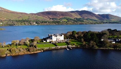 Fototapeta premium Panoramic view of a castle on a lake surrounded by hills