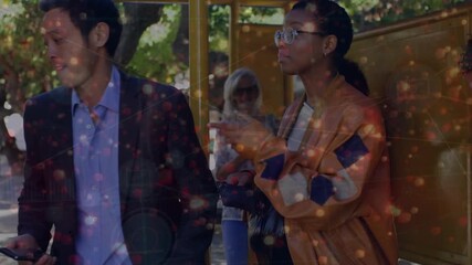 Animation of network of digital icons and light sparks against group of diverse people at bus stop - Powered by Adobe