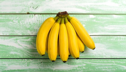 Bunch of ripe bananas on a light green wooden surface