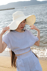 夏の百道浜を歩く若い女性