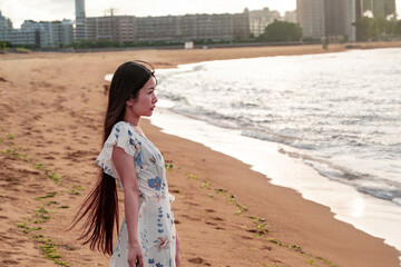 夏の百道浜を歩く若い女性