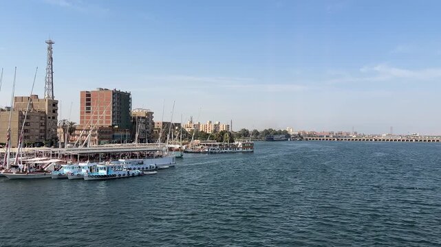 Nile River cruise view with boats and city buildings en route to Esna Lock, Egypt