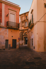 Historic street in Nardò leading toward baroque church facade