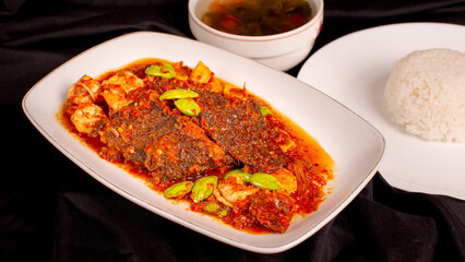 Fried flat fish with red chili sauce and stinky beans. We also called sambal balado. Served with rice and soup. Perfect for recipe, catalogue, promotion, or any cooking contents
