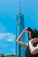 夏の福岡タワーと若い女性
