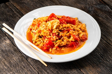 Omelette with tomatoes on a dark background.Asian food. Chinese cuisine